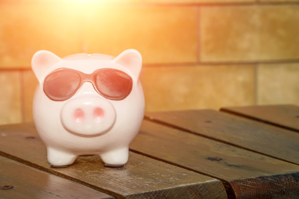 一只戴着黑色眼镜的粉色小猪放在一张有复印空间的木凳上，照片上有照明图片下载