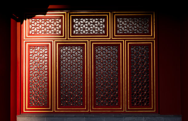 中国传统宫殿建筑的一部分，装饰着金色框架和格栅的辉煌红色彩绘窗户图片下载