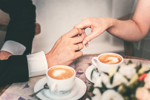 相爱的夫妇在婚礼后喝咖啡。手新婚夫妇图片下载