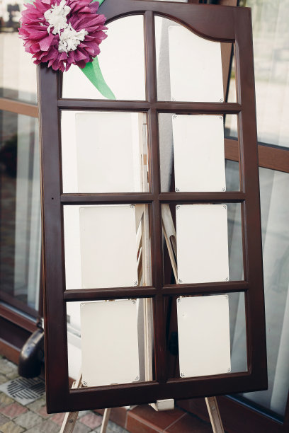 餐厅婚宴上的复古、质朴的座位图板，木框上的旧纸上的宾客名单特写图片下载