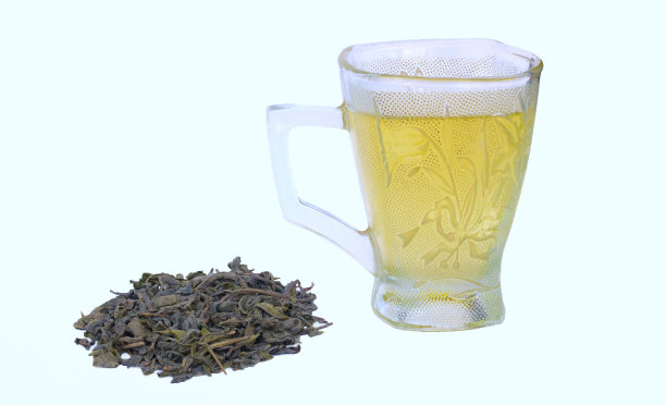 一杯绿茶，里面有一堆干绿茶叶子图片下载