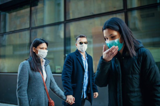 在城市里戴着口罩咳嗽的年轻女孩图片下载