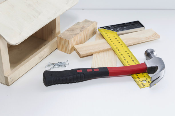 鸟喂食器附近的钉子用锤子，特写图片下载