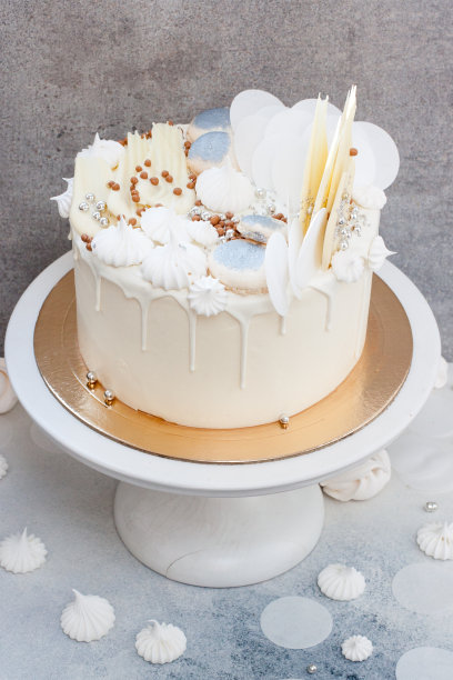 优雅的白色婚礼蛋糕，有巧克力装饰，蛋白酥和杏仁饼干。图片下载