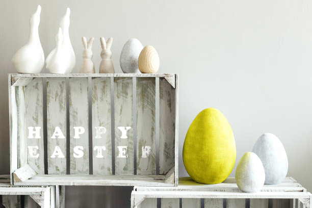 亮黄色陶瓷鸡蛋装饰在单色灰色的背景。复活节快乐祝福图片下载