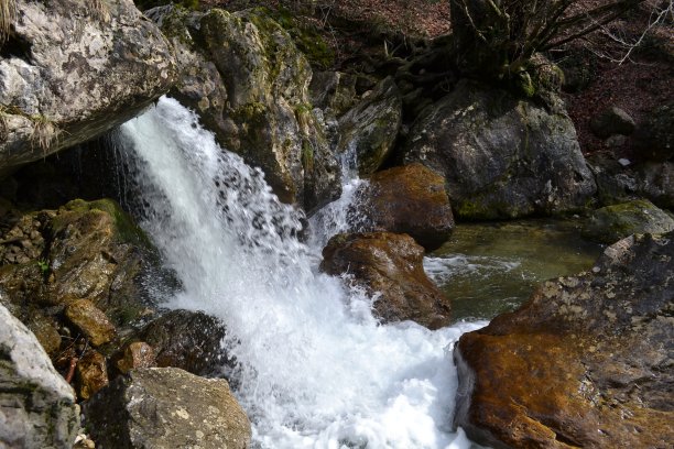 瀑布般的山涧溪流在岩石之间。图片下载