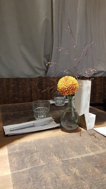 深褐色的静物画，配上秋季草本植物的小瓶和桔黄色的菊花。老木桌上放着一杯水和花束。复古对象和复制空间。图片下载