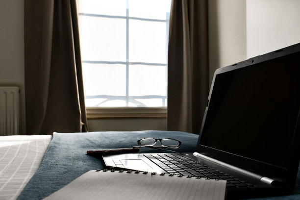 床上放笔记本，笔记本，眼镜和手机图片下载