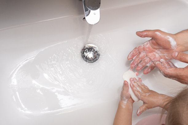 孩子和父亲洗手以保护自己免受冠状病毒感染。从浴室顶部俯瞰。Copyspace。图片下载