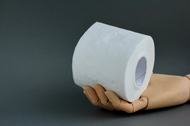 灰色背景上的玩具木制手卷厕纸。由于冠状病毒、Covid-19、卫生、恐慌等原因导致商店缺少卫生纸的概念。副本的空间。图片下载