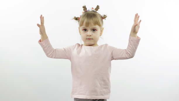 积极的女孩穿着粉红色的衬衫跳舞。快乐的四个小孩。白色背景图片下载