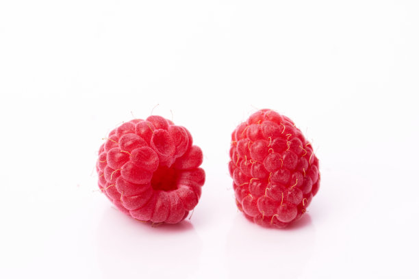 白色背景上的两个红色多汁的覆盆子图片下载