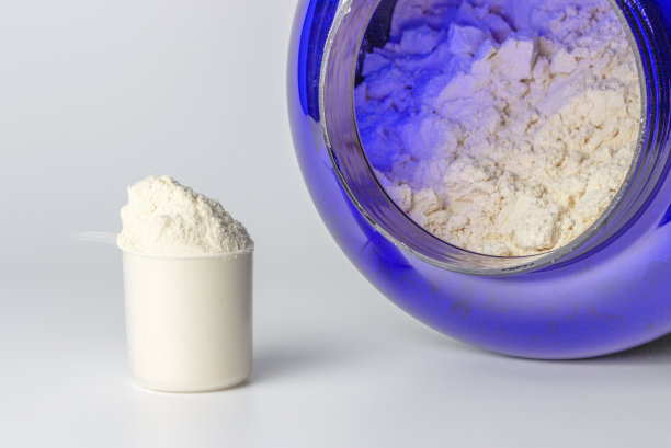 浅色背景上的蛋白质粉勺和罐头，运动营养概念图片下载