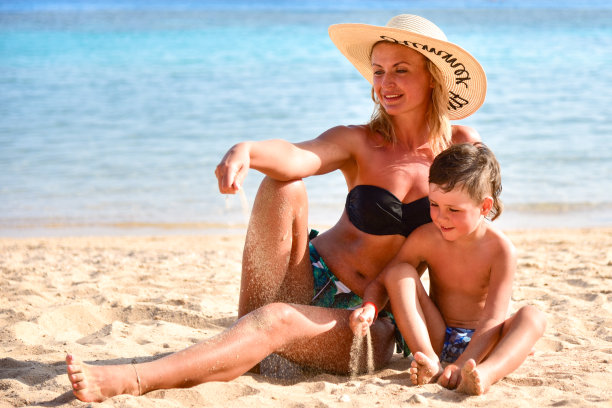 海滩上，妈妈和儿子玩沙嬉戏图片下载