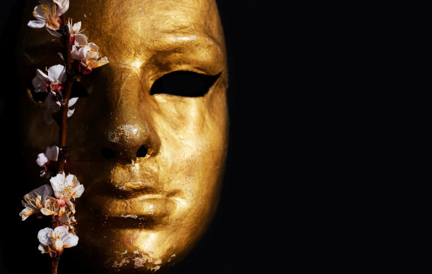 金色面具上的黑色背景与樱花枝。图片下载