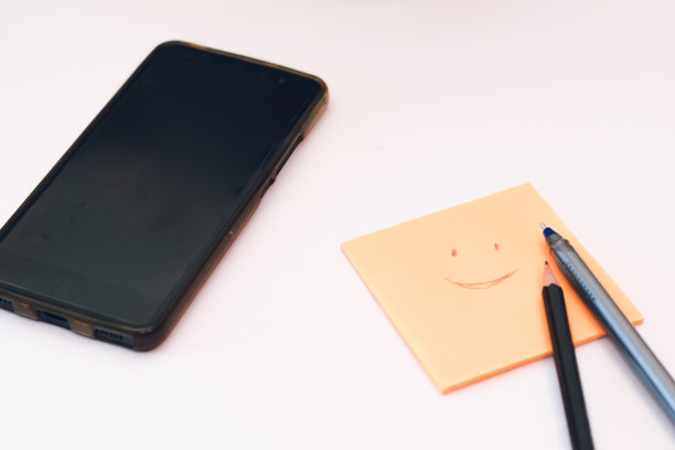 创意平面躺照片的工作办公桌与纸贴纸，智能手机，钢笔和铅笔。在冠状病毒大流行隔离期间在家工作。远程办公的概念图片下载