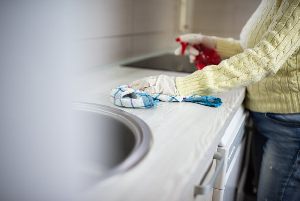 戴着手术手套的老妇人在家打扫卫生图片下载