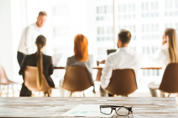 模糊的照片离焦。一群年轻的商人在办公室里一起工作和交流。公司商务人员和经理在开会。图片下载