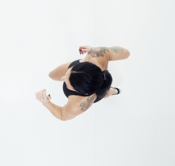 白人年轻女性穿着胸罩在白色背景前慢跑图片下载