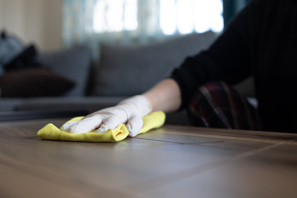 女性双手用消毒液擦拭桌面。图片下载