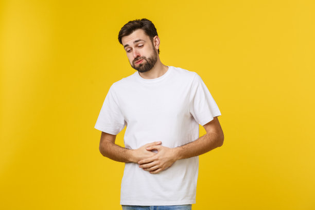 年轻的白人男子身穿棕色夹克，感到不适，患有胃痛，痛苦疾病概念图片下载