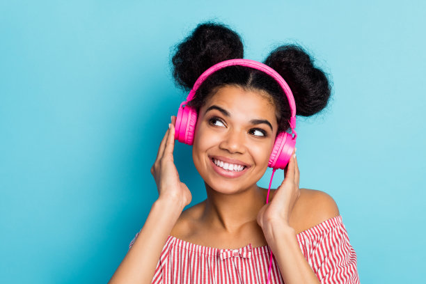 特写照片有趣漂亮的黑皮肤女士听音乐现代科技耳机看起来梦幻的空空间穿着时尚的红白条纹衬衫，肩部孤立的蓝色背景图片下载