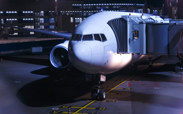 全白客机起飞前。飞机停在夜间机场。图片下载