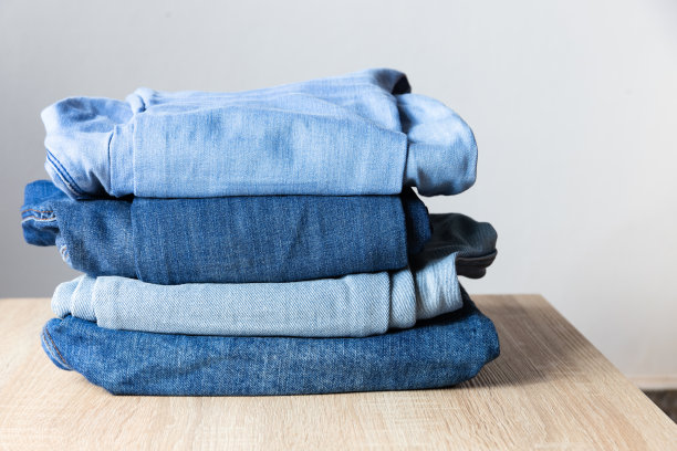 不同颜色的牛仔裤叠成一堆图片下载