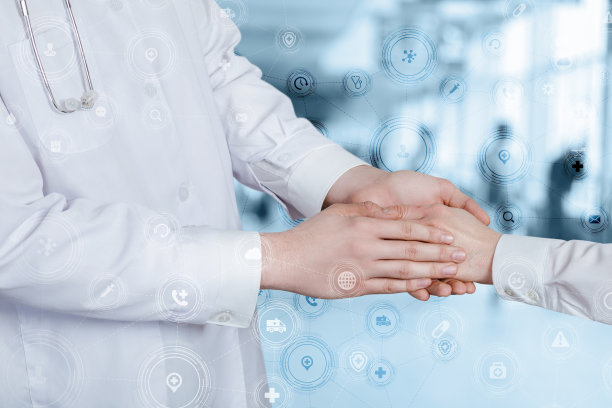 医生握着病人的手在模糊的背景上。图片下载