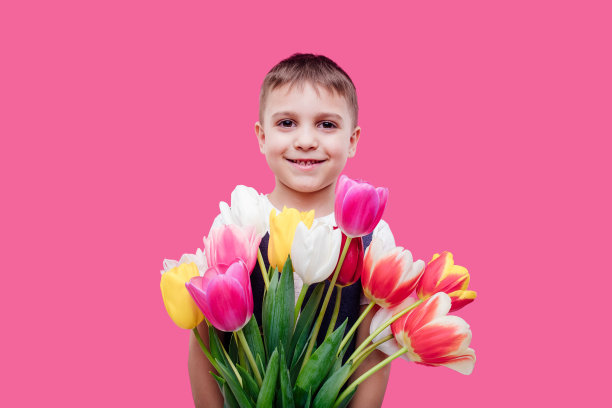 一个快乐的小男孩拿着一束郁金香图片下载