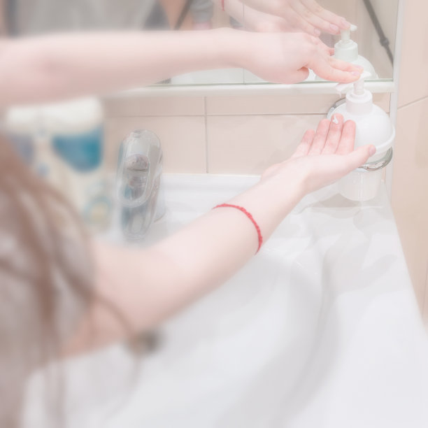 使用洗手液和洗手液的女孩的手。卫生、消毒、防止细菌和病毒的概念。光线柔和的背景。有选择性的重点图片下载