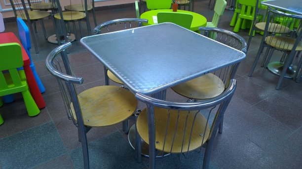 购物中心美食广场的空方形金属桌子和椅子。没有人。隔离概念。金融和经济危机。对病毒采取保护性的抗菌措施。图片下载