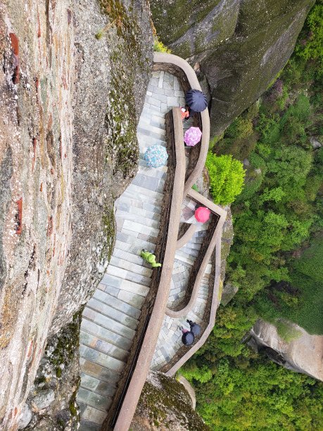 雨伞在一座寺院的陡峭台阶上列队行进图片下载
