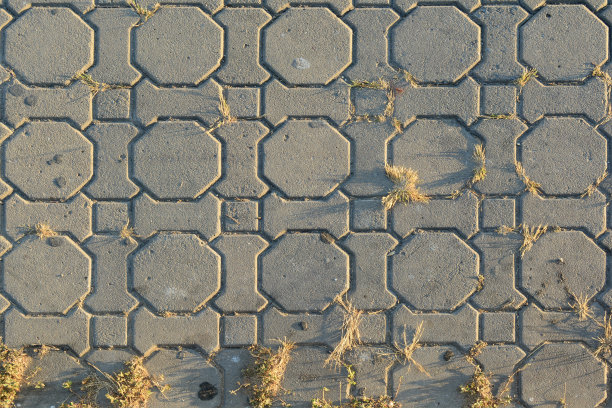 背景是灰色的水泥砖和小的干草和傍晚的阳光图片下载