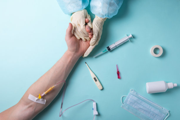 平躺在蓝色背景的医生桌子上。医生和病人的手。图片下载