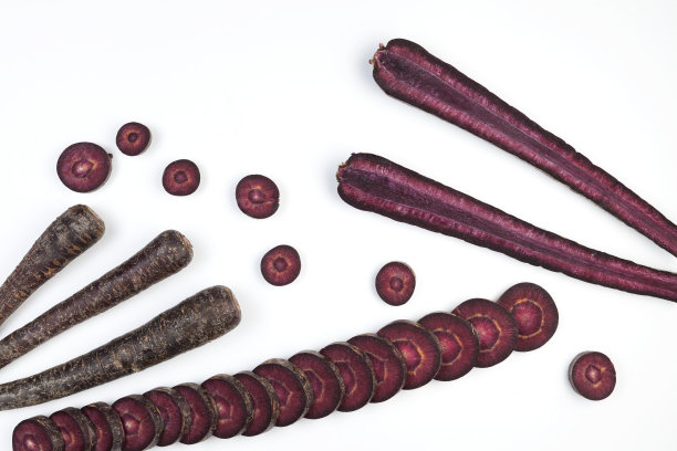华丽的色彩鲜艳的蔬菜。一套紫色的胡萝卜在光的背景。本空间图片下载