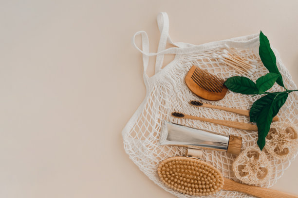 竹制牙刷、牙膏、天然毛刷、自我护理化妆品、白色棉网袋等。图片下载