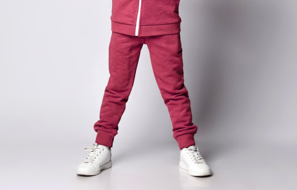 特写图像的腿上的孩子在运动服和白色运动鞋站在灰色与复制空间图片下载