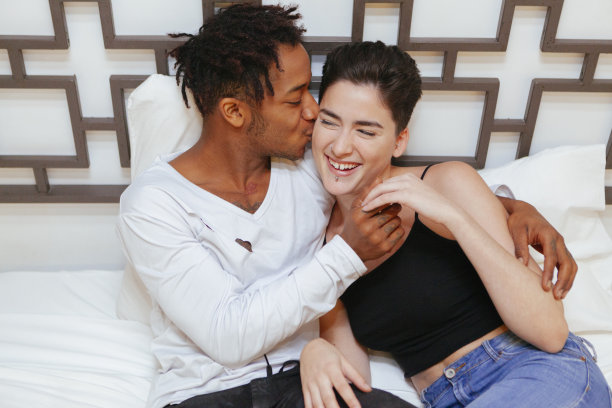 愉快的异族夫妇在卧室里享受亲密时刻。图片下载