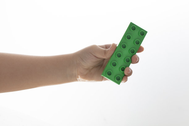 小男孩手拿塑料积木图片下载