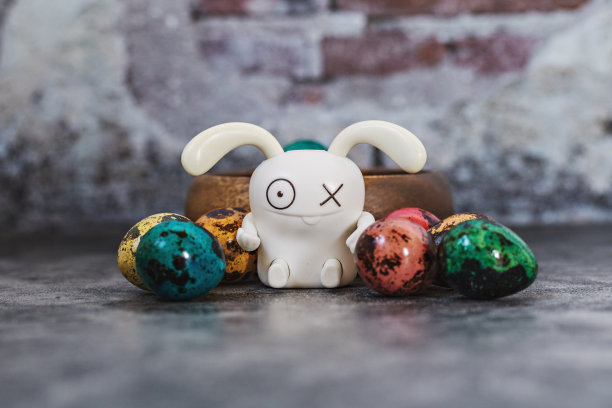 复活节快乐，鹌鹑在蓝色混凝土背景的木碗里画斑点蛋，兔子，春天东正教和天主教节日的象征图片下载