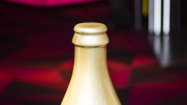 金色瓶颈香槟。瓶子在梯度灰色背景图片下载