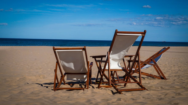 空荡荡的日光浴躺椅面向大海图片下载