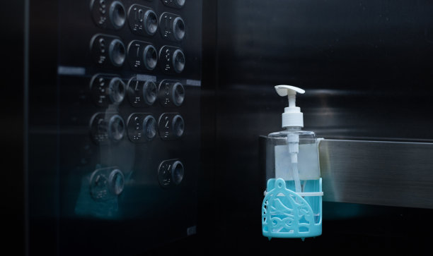 消毒、卫生和保健理念。在公寓、医院和工作场所的电梯或电梯内使用防新型冠状病毒或冠状病毒Covid-19洗手液凝胶瓶。图片下载