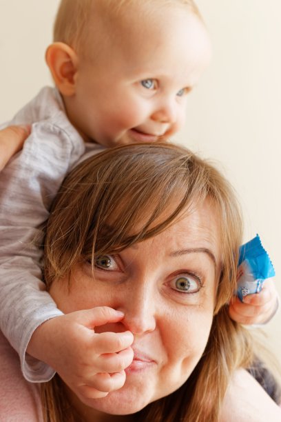 母婴概念：幸福的母亲和宝宝在卧室玩耍图片下载