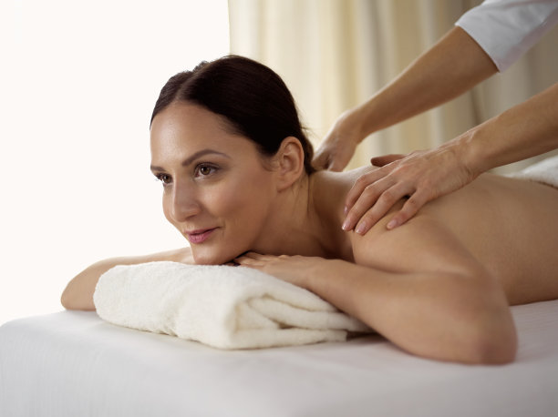 金发美女在水疗沙龙享受背部按摩，美容概念图片下载