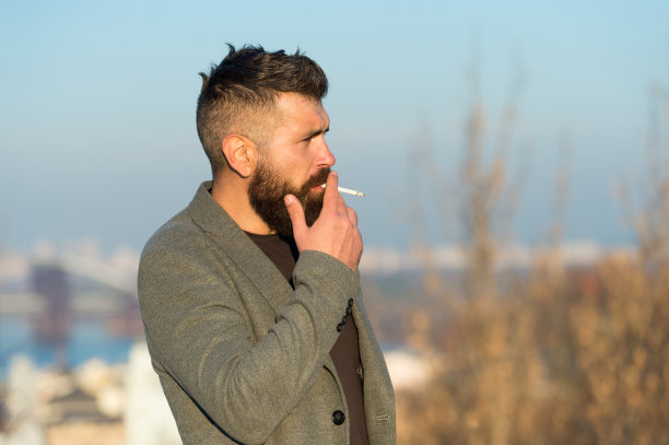 吸烟有害健康。户外胡须男士吸烟场景。图片下载