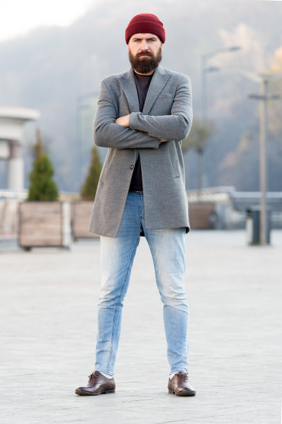 时尚休闲春季服装。男装和男性时尚理念。留着胡子的时髦潮人穿着时尚的外套和帽子。舒适的服装。清爽的散步。潮人服装和帽子配饰图片下载