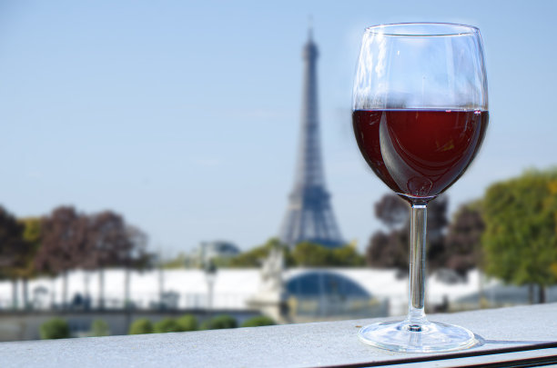 在埃菲尔铁塔上，一杯葡萄酒模糊了背景图片下载