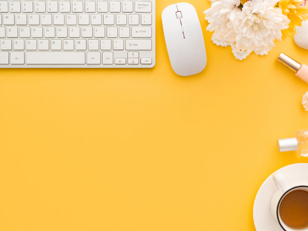 键盘鼠标，一杯茶和牡丹花，化妆工具和化妆品附近孤立在黄色的背景。图片下载